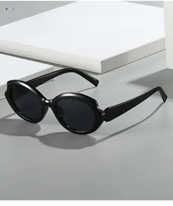 Detail view of black futuristic wrap-around sunglasses with glossy retro oval frames