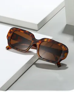 Macro detail of tortoiseshell square frame sunglasses with metal hinge on white block