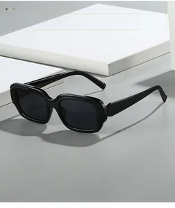 Detail of glossy black rectangular sunglasses on a geometric white display stand