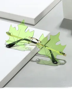 Detail of light green maple leaf rimless sunglasses with gold frame on white steps