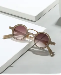 Detail of retro oval eyewear with gold hollow bridge and purple gradient lenses