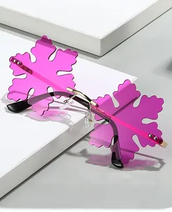 Detail of rose red snowflake shaped rimless sunglasses with gold metal frames on white stand