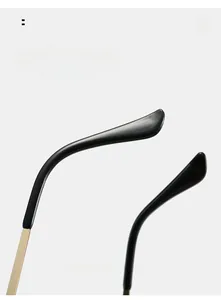 Close-up of golden metal glasses legs with black curved ear hooks for ergonomic comfort