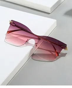 Detail of rimless cat-eye sunglasses with gradient purple lenses and gold metal accents