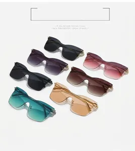 Detailed close-up of rimless cat-eye sunglasses with gradient lenses and golden metal temples