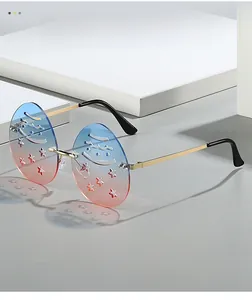 Detail of rimless round sunglasses with blue-red gradient lenses and star cut-outs