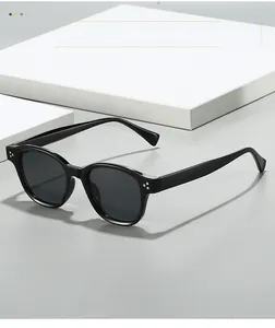 Detailed close-up of retro black sunglasses with silver rivet accents and dark lenses