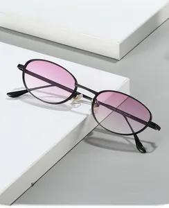 Détail de lunettes ovales en métal avec verres dégradés roses et plaquettes en silicone