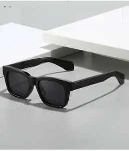 Detail of square polarized sunglasses with premium black frames on a minimal grey surface