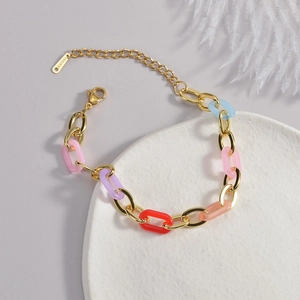 Detail of a gold stainless steel bracelet with colorful acrylic links and lobster clasp