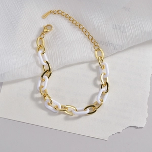 Detailed macro of gold and white link chain with lobster clasp and S-STEEL tag