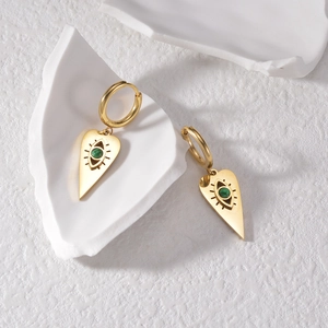 Détail de boucles d'oreilles œil maléfique en or 18K avec malachite sur fond de pierre
