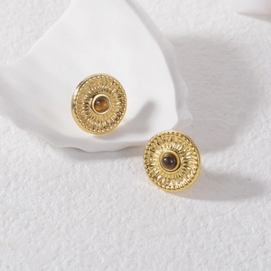 Détail de boucles d'oreilles rondes dorées vintage avec pierre oeil de tigre marron