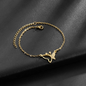 Gold butterfly bracelet with pavé crystal accents on black leather background