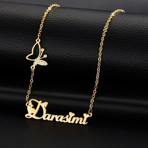 Detailed close-up of a golden personalized name necklace with a crystal butterfly charm