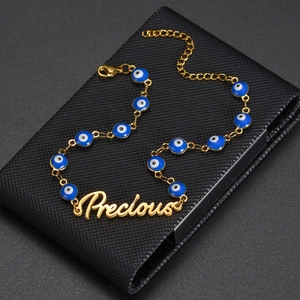 Evil eye gold chain necklace featuring blue beads and a Precious script pendant