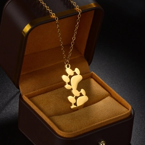 Minimalist gold stainless steel bear paw pendant necklace displayed in a velvet jewelry box