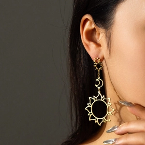 Detail of 18K gold butterfly earrings with moon and sun hollowed star pendants