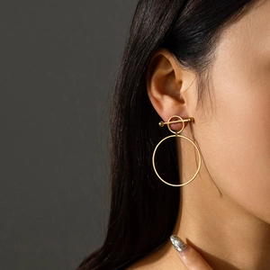 Close-up of a model wearing French vintage 18K gold butterfly geometric earrings