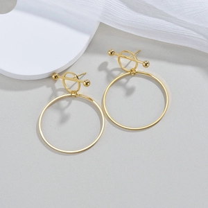 Detail view of gold butterfly earrings with geometric circles and polished gold finish