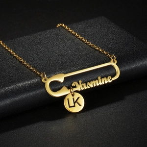 Collier épingle à nourrice en acier doré avec pendentif prénom Yasmine sur fond noir