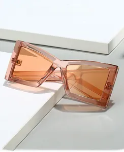 Close-up of orange translucent oversized cat eye frames on a geometric white display