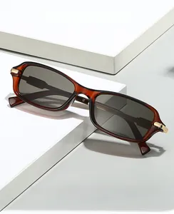 Detail view of retro amber tortoiseshell sunglasses with golden metal hinge accents