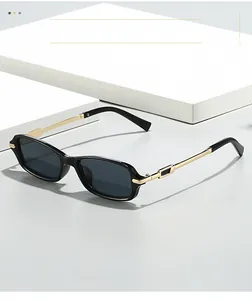 Detail of rectangular black sunglasses with gold metal temples and geometric textured design