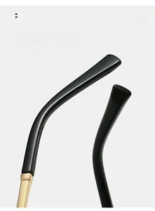 Detail of curved black sunglasses legs with ergonomic design and golden metal hinges
