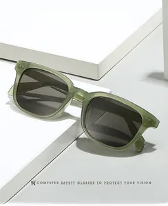 Macro view of olive green square sunglasses on a geometric display stand