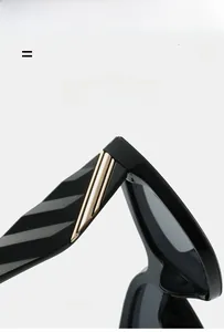 Detail view of black square sunglasses featuring elegant gold metallic temple accents