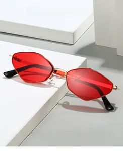 Close-up of polygon gold metal frames with red lenses on minimalist display