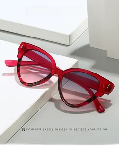 Détail de lunettes de soleil œil-de-chat rouges avec motif écaille sur socle géométrique