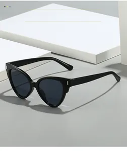 Détail de lunettes de soleil œil-de-chat noires avec rivets en argent sur monture polie