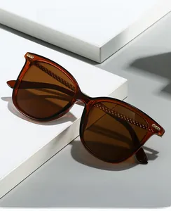 Close-up of brown translucent glasses with textured metal temples on a white pedestal