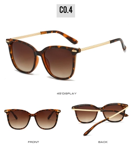 Detail of tortoiseshell sunglasses with gradient lenses and textured gold metal temples