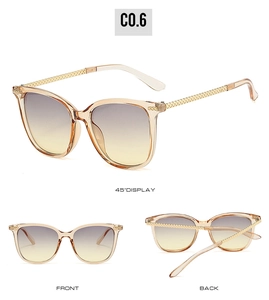 Detail view of amber resin sunglasses with gradient lenses and woven gold metal temples