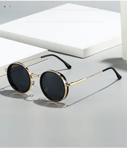 Detailed view of round sunglasses with textured gold metal frames and black lenses