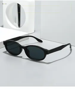 Detail of sleek black oval sunglasses with dark grey lenses on white geometric props