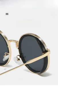 Detailed macro view of gold metal round frame sunglasses with textured rim and silicone nose pads