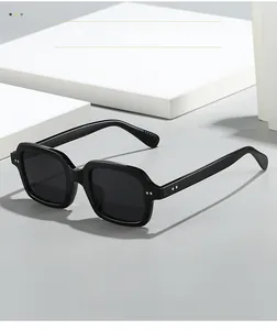 Detail of square black sunglasses with metal rivet accents on high-quality frames