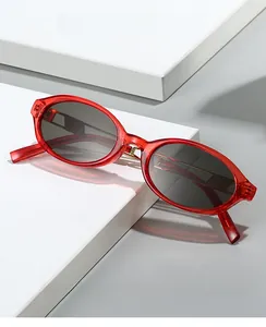 Macro detail of red translucent oval frame and grey lenses on stylish sunglasses