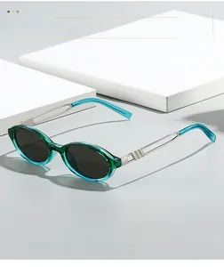 Detail of vintage oval sunglasses with translucent teal frames and silver metal hinges