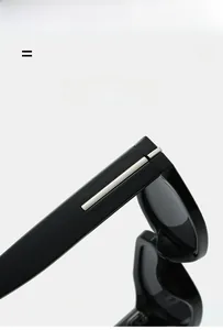 Macro detail of glossy black sunglasses frame with silver metal hinge accents