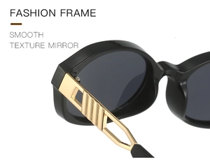 Close-up of black acetate frame sunglasses with hollow gold metal striped temples