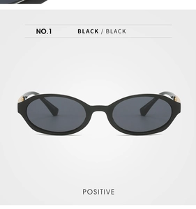 Front view of black oval frame sunglasses with refined gold metal hinge detail