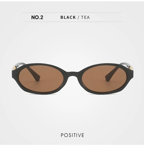 Front view of black oval sunglasses with tea lenses and gold metal temple accents