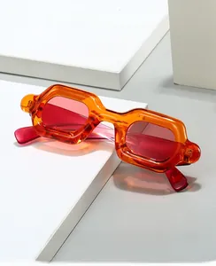Detail of trendy Y2K thick orange frame sunglasses on a minimalist white display