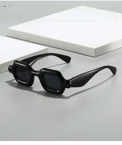 Detailed view of Y2K style black thick frame sunglasses on a geometric display stand