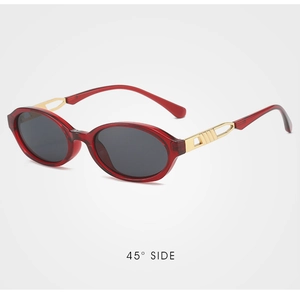 Detail view of red oval sunglasses with gold textured metal temples and 45-degree side angle